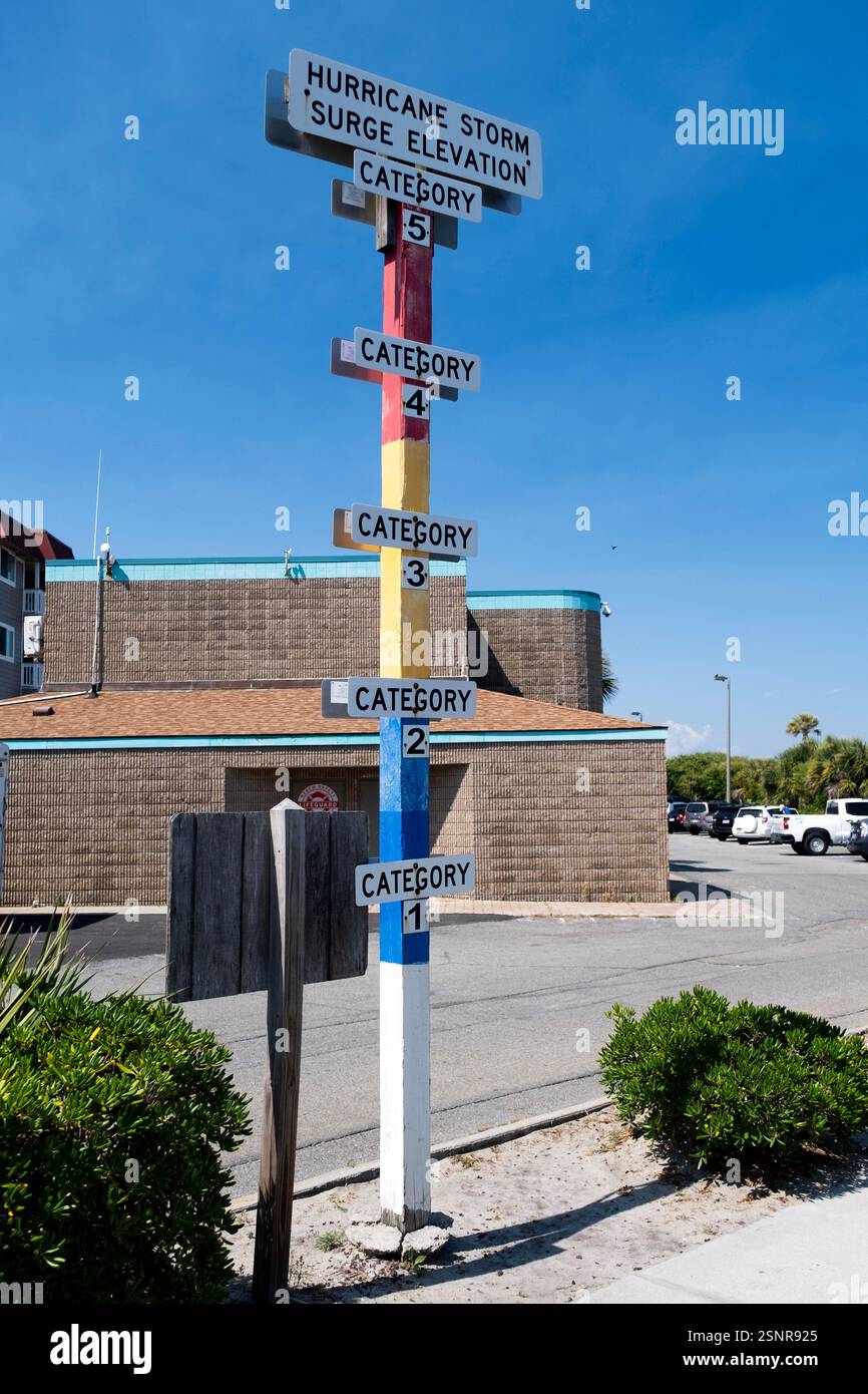 Haut poteau avec signalisation avertissant du danger de l'onde de tempête hauteur d'inondation des ouragans le long de la côte atlantique à Tybee Island, Géorgie Banque D'Images