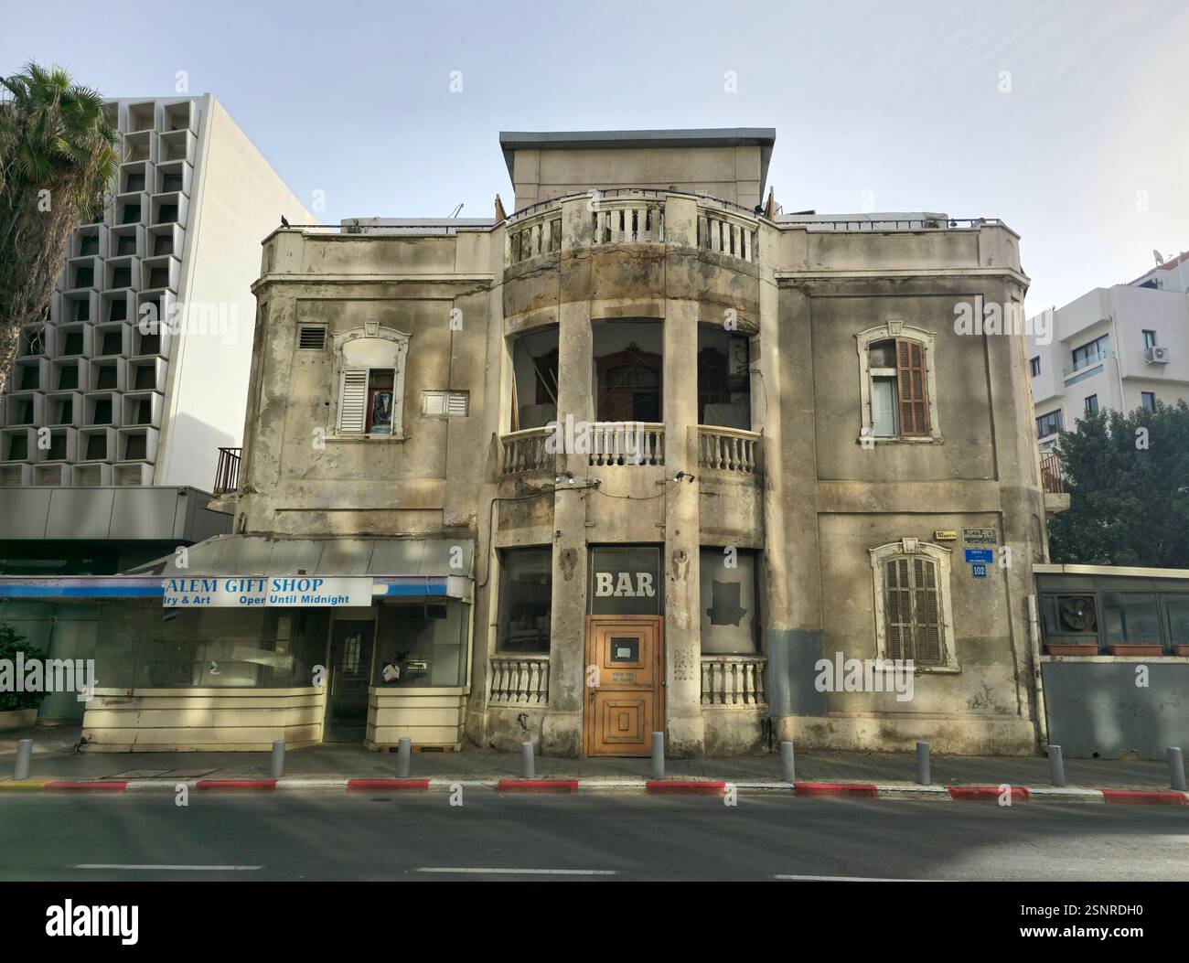 Un ancien bâtiment historique à rénover avec une construction d'un nouveau bâtiment résidentiel derrière elle. Hayarkon Street, tel Aviv, Israël. - Image de stock capturée avec un smartphone