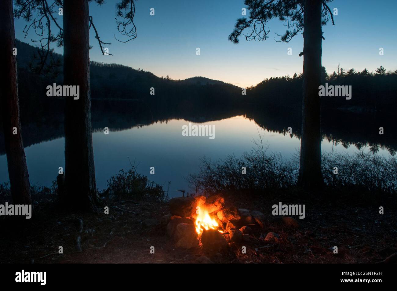 Feu de camp le long de la rive de Whortleberry Pond dans les montagnes Adirondack de l'État de New York Banque D'Images