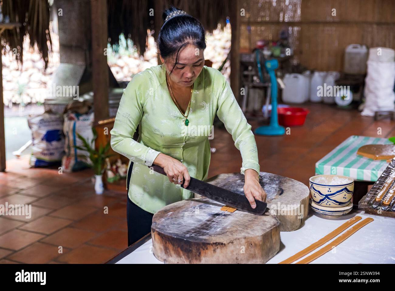 Un ouvrier prépare des paquets traditionnels de bonbons à la noix de coco, dans une usine locale de bonbons à la noix de coco, quoi son, Vietnam. Lundi 11 novembre 2024. Banque D'Images