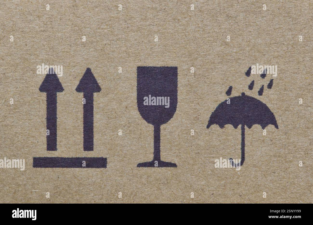 Les étiquettes d'avertissement sur la silhouette de la boîte en carton forment des flèches en verre de parapluie, cette façon vers le haut fragile garder sec instructions logistiques de transport. Banque D'Images