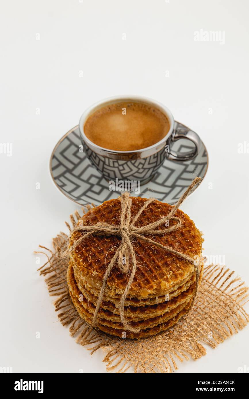 Des gaufres au caramel fraîchement préparées s'empilent à côté d'une tasse de café à la vapeur, créant une délicieuse friandise parfaite pour célébrer la journée nationale du caramel dans un cadre confortable Banque D'Images