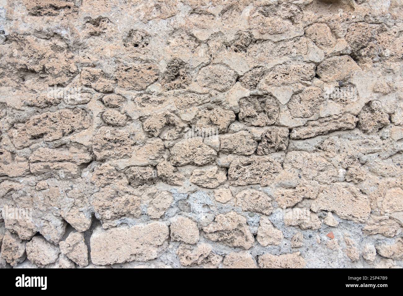 Une capture détaillée d'un mur de pierre vintage et rustique, mettant en valeur sa texture inégale, son motif naturel et son ambiance historique, idéal pour les arrière-plans Banque D'Images