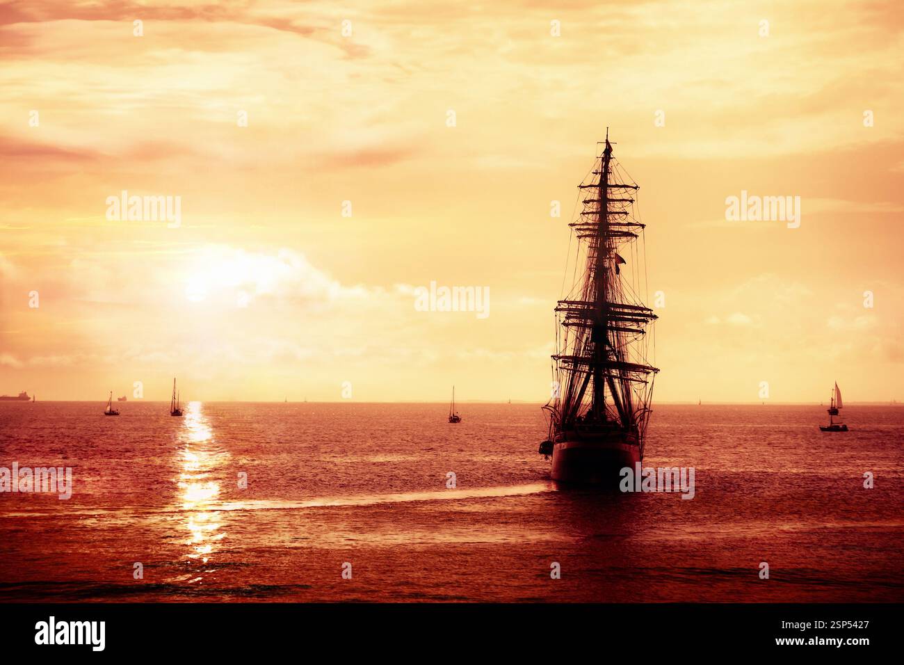 Chercheur de trésor, navire fantôme naviguant en haute mer au crépuscule. Hollandais volant dans le coucher de soleil orange. Banque D'Images