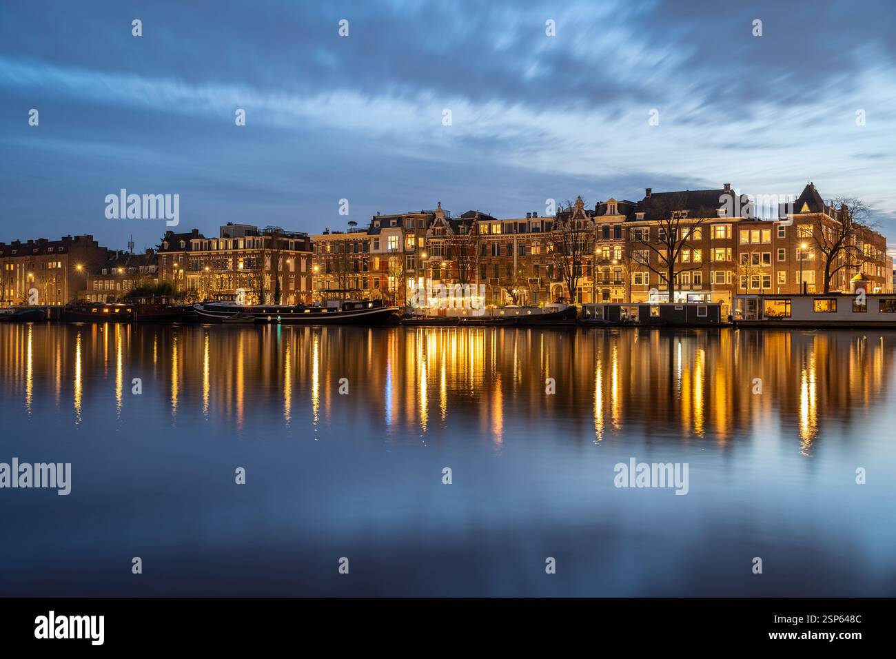 Amsterdam Diamantbuurt et rivière Amstel au coucher du soleil, front de mer avec péniches et maisons hollandaises typiques reflétées dans la surface de l'eau Banque D'Images