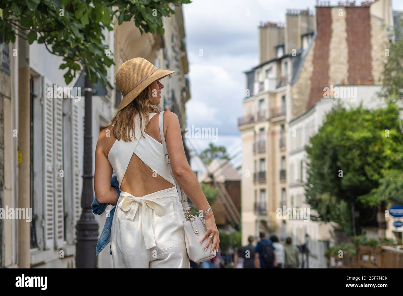 Femme marchant dans la rue parisienne avec tenue d'été. Banque D'Images