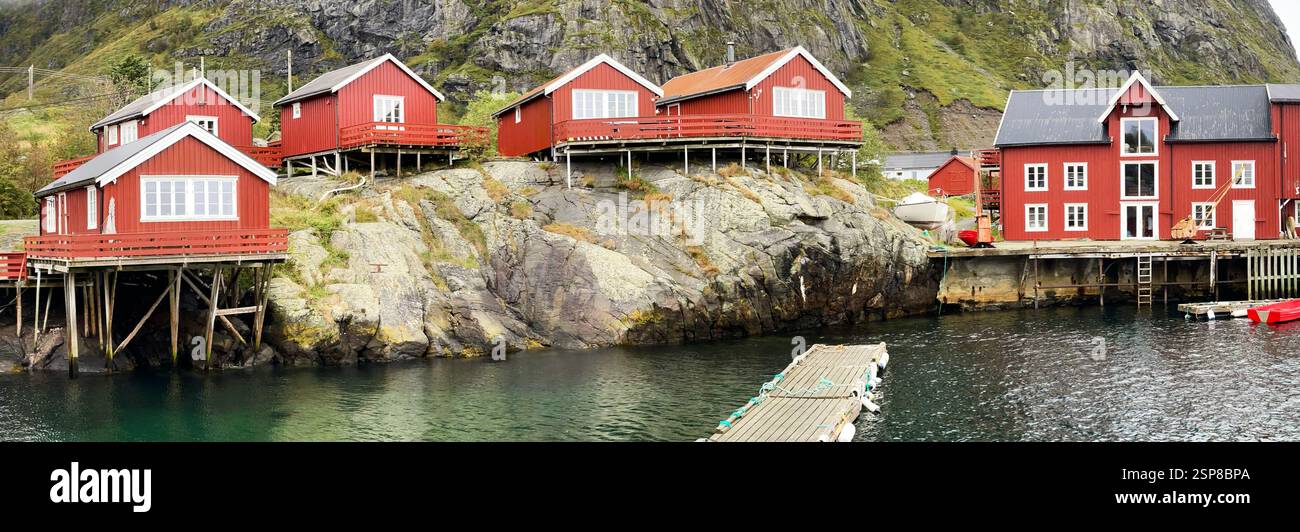 Maison en bois sur pilotis rouges typique des villages de l'archipel des Lofoten au bord de l'eau avec ponton Banque D'Images