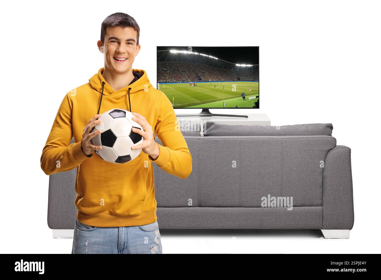 Supporter de football tenant un ballon et souriant devant le canapé et la télévision isolé sur fond blanc Banque D'Images