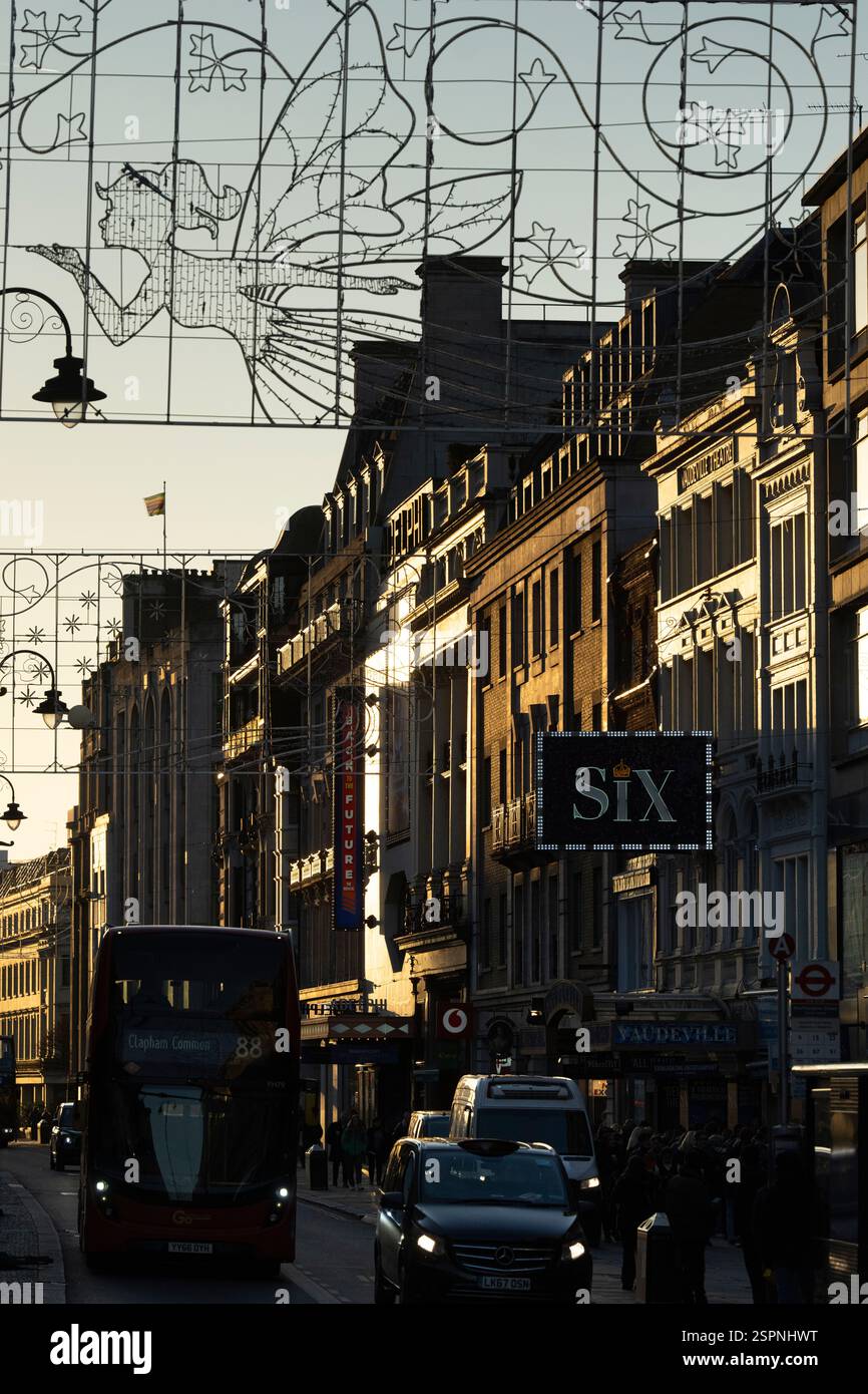 Scène de soirée sur le Strand, Londres, près du Théâtre Vaudeville. Bus et voitures sont dans la rue, et les chapiteaux de théâtre sont éclairés. Banque D'Images