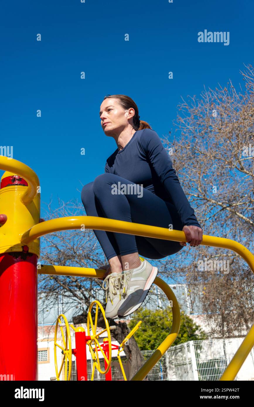 femme utilisant des barres dans le gymnase extérieur, poussez vers le haut des exercices. Banque D'Images