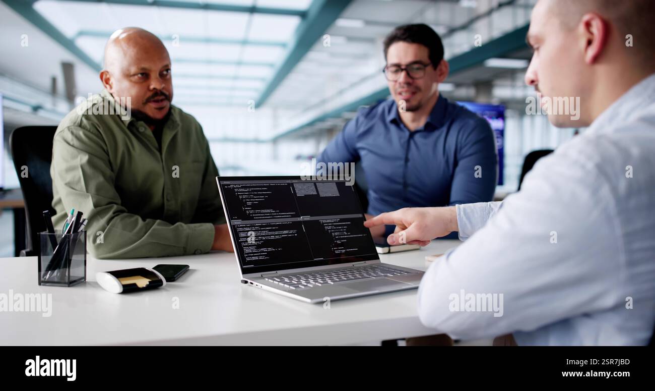 Groupe diversifié de développeurs de logiciels codant sur des ordinateurs portables en réunion Banque D'Images