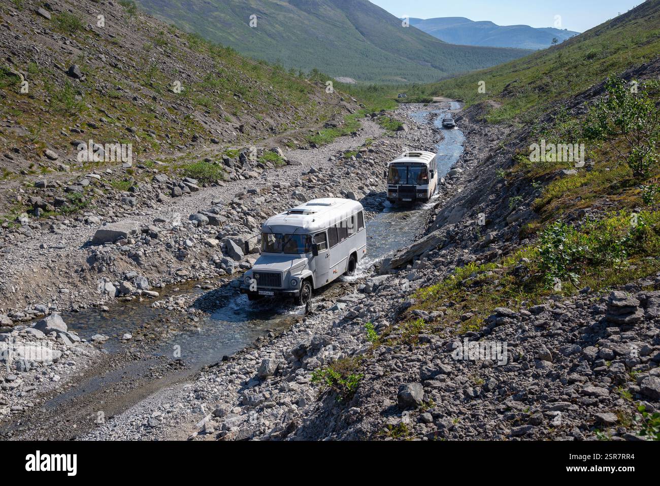 Khibiny, RUSSIE - 27 JUILLET 2024 : bus avec des touristes sur la rivière de montagne. Khibiny, région de Mourmansk, Russie Banque D'Images