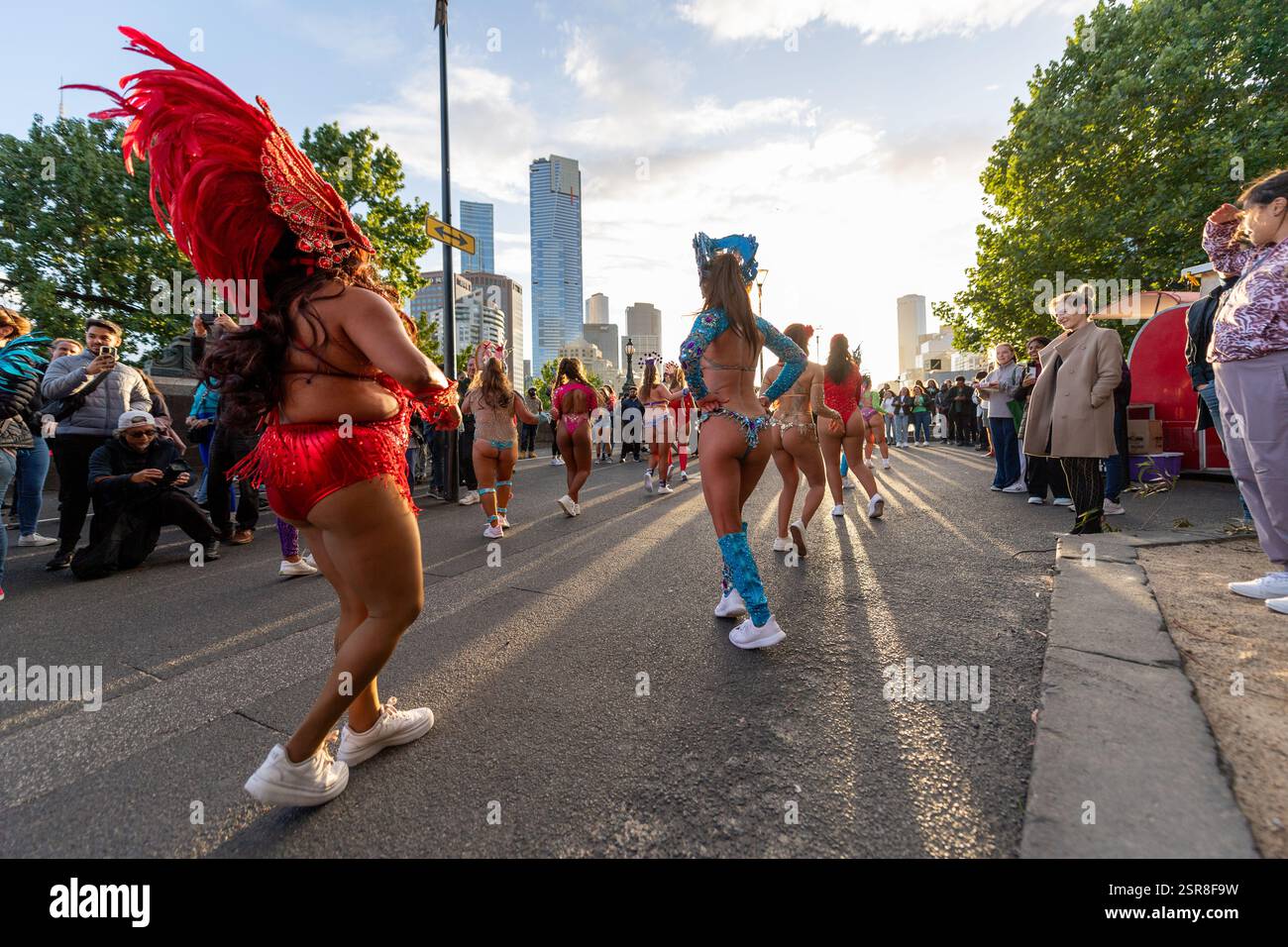 MELBOURNE, AUSTRALIE. 15 février 2025. Sur la photo : danseuses de carnaval rétroéclairées au coucher du soleil dans des costumes colorés vibrants dansent dans la rue au Festival Afro Caribbean, Federation Square, Melbourne, Australie le 15 février 2025. Crédit : Karl Phillipson / Alamy Live News Banque D'Images