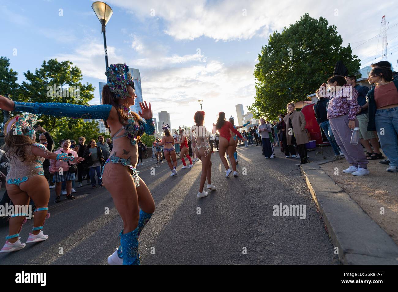 MELBOURNE, AUSTRALIE. 15 février 2025. Sur la photo : danseuses de carnaval rétroéclairées au coucher du soleil dans des costumes colorés vibrants dansent dans la rue au Festival Afro Caribbean, Federation Square, Melbourne, Australie le 15 février 2025. Crédit : Karl Phillipson / Alamy Live News Banque D'Images