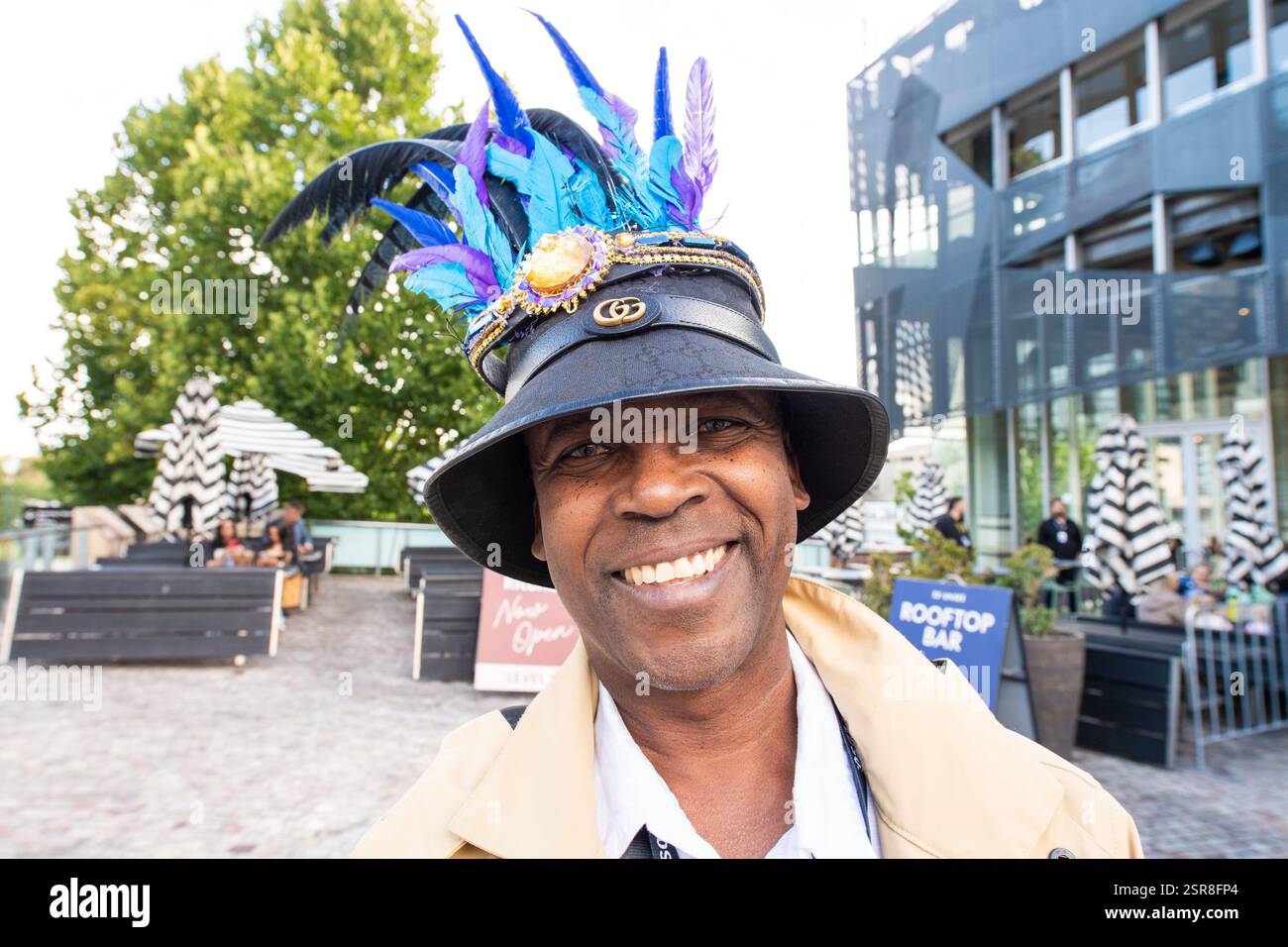 MELBOURNE, AUSTRALIE. 15 février 2025. Sur la photo : célèbre DJ Stick Mareebo, présentateur de l'Afro Caribbean Festival pose dans un chapeau noir avec des plumes bleu vif souriant chaleureusement à la caméra, Federation Square, Melbourne, Australie le 15 février 2025. Crédit : Karl Phillipson / Alamy Live News Banque D'Images