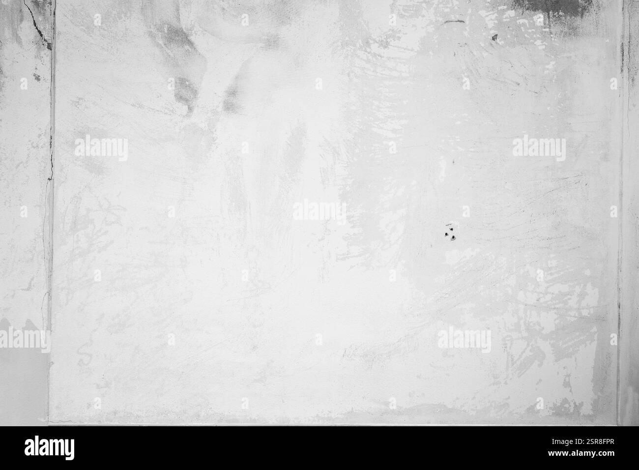 Vue avant d'un mur blanc altéré avec des rayures et des taches en noir et blanc. Fond texturé plein cadre abstrait haute résolution, espace de copie. Banque D'Images