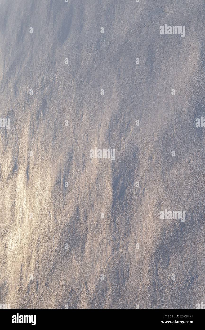 Gros plan d'un mur de pierre propre et inégal peint en blanc. Belle lumière latérale chaude crée des ombres douces. Fond texturé abstrait, espace de copie. Banque D'Images