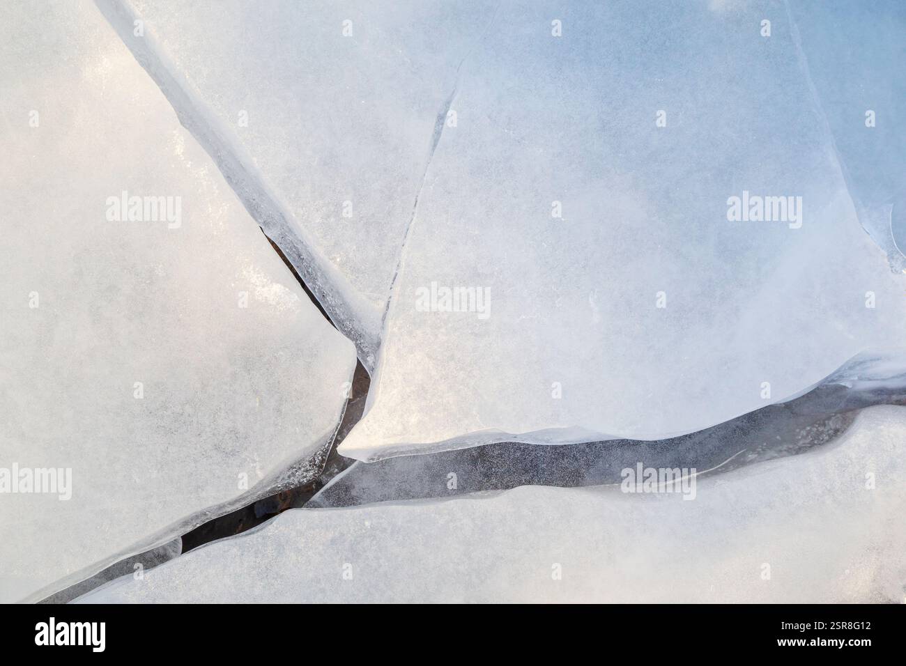 Gros plan de glace fissurée sur un lac gelé en hiver, vu d'en haut. Arrière-plan abstrait. Espace de copie, vue de dessus. Idéal pour la toile de fond hivernale. Banque D'Images