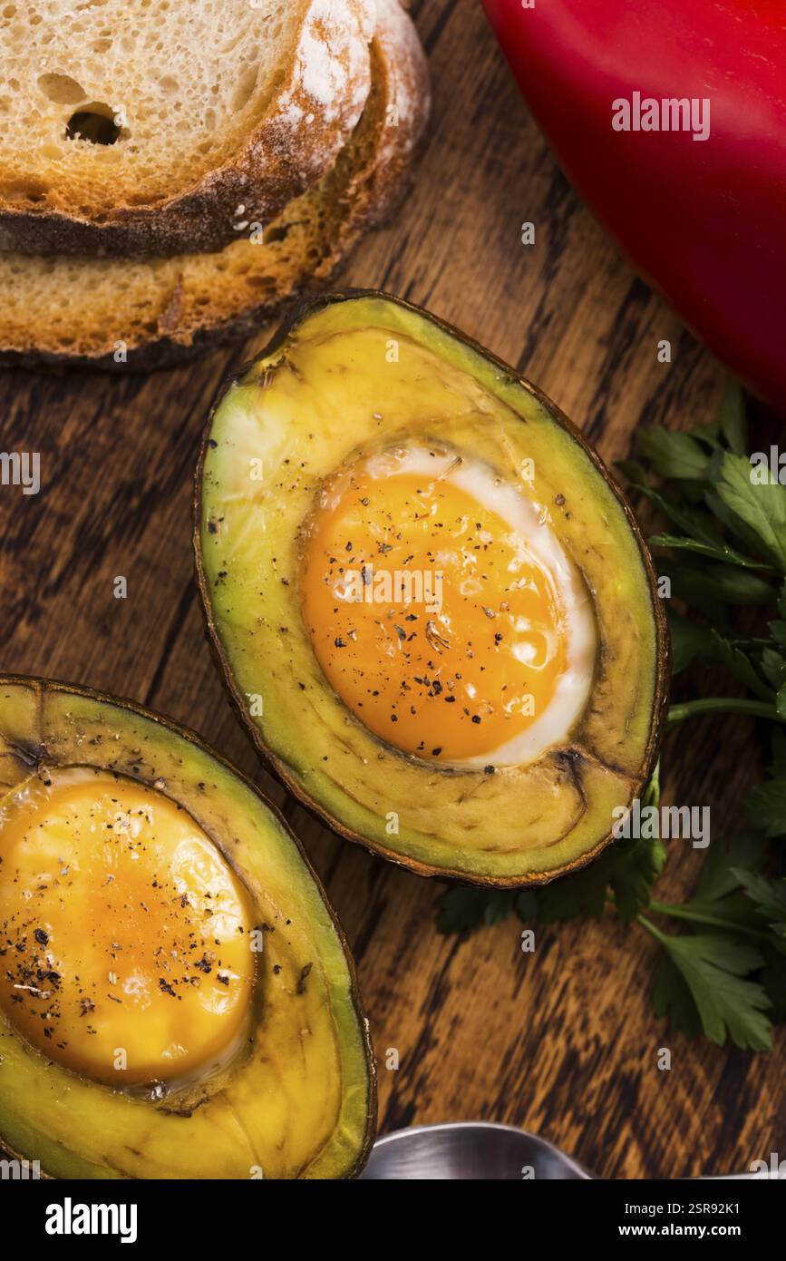 Oeufs bio faits maison cuit dans avocat avec sel et poivre Banque D'Images