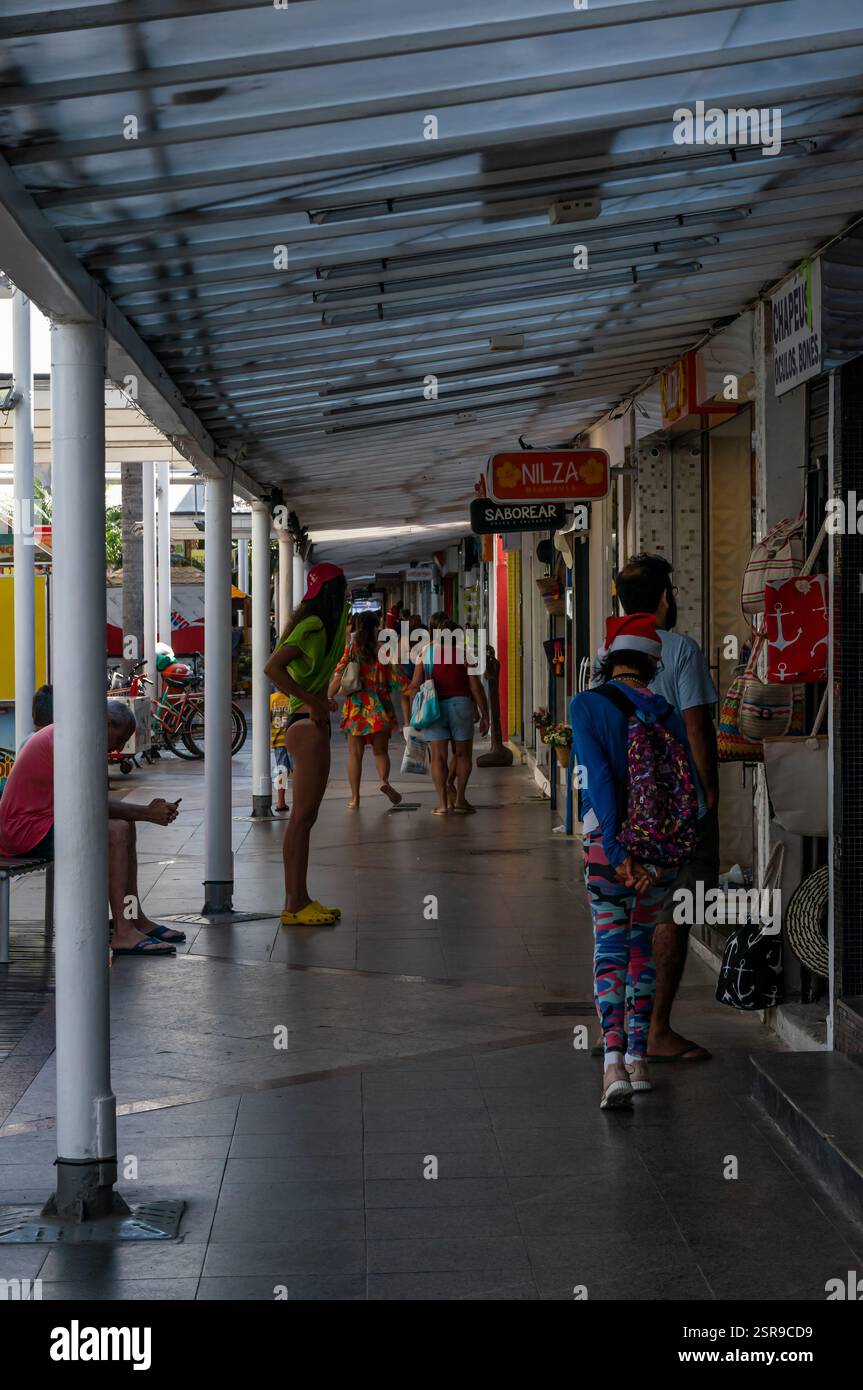 Les acheteurs explorent les petites boutiques du centre commercial Rua dos Biquínis, marchant le long d'un couloir couvert dans le quartier de Gamboa par un après-midi chaud et ensoleillé d'été. Banque D'Images