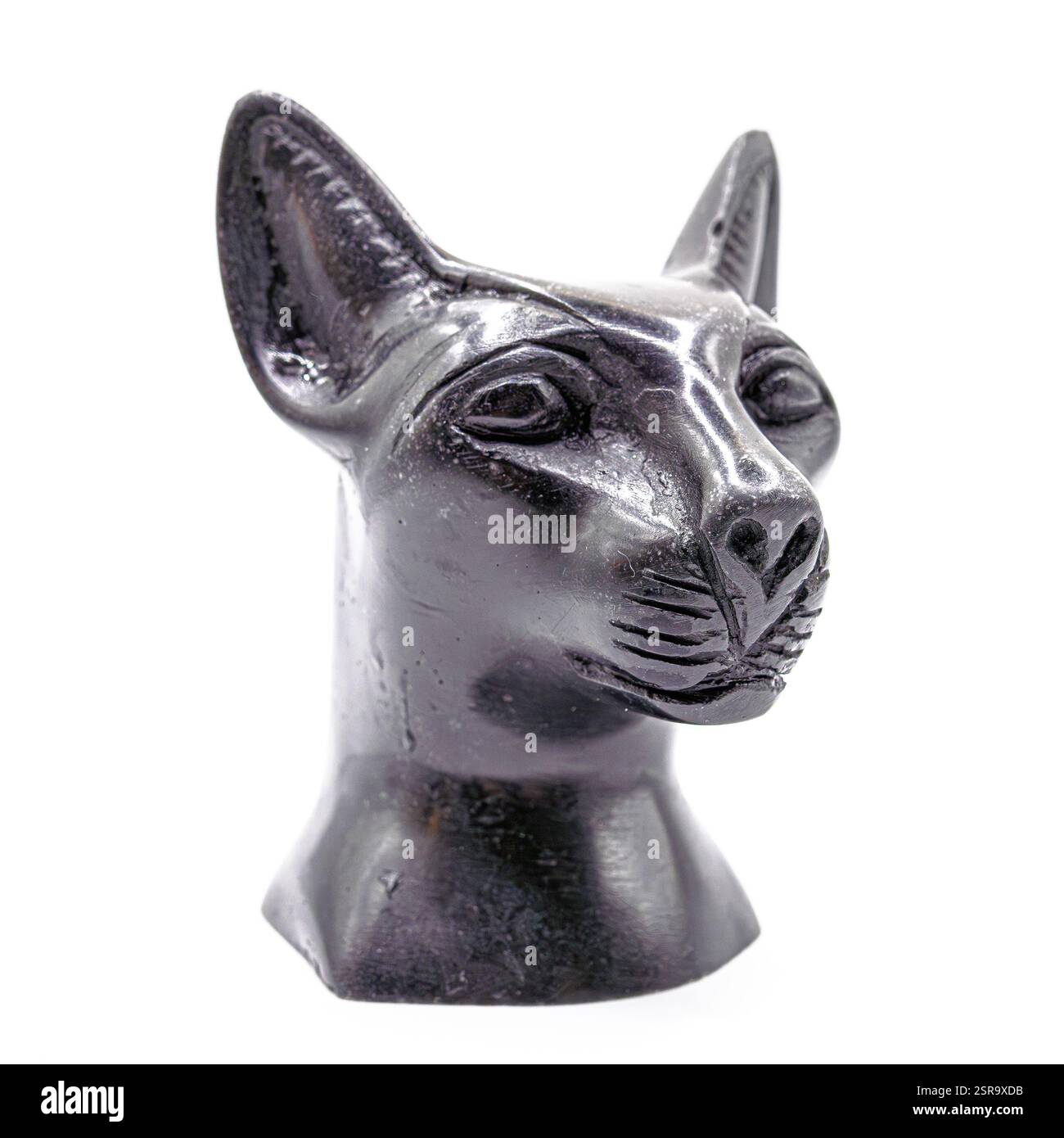 Statue de chat en pierre noire inspirée de l'art égyptien antique, présentant des détails complexes et une expression royale sur un fond blanc. Banque D'Images