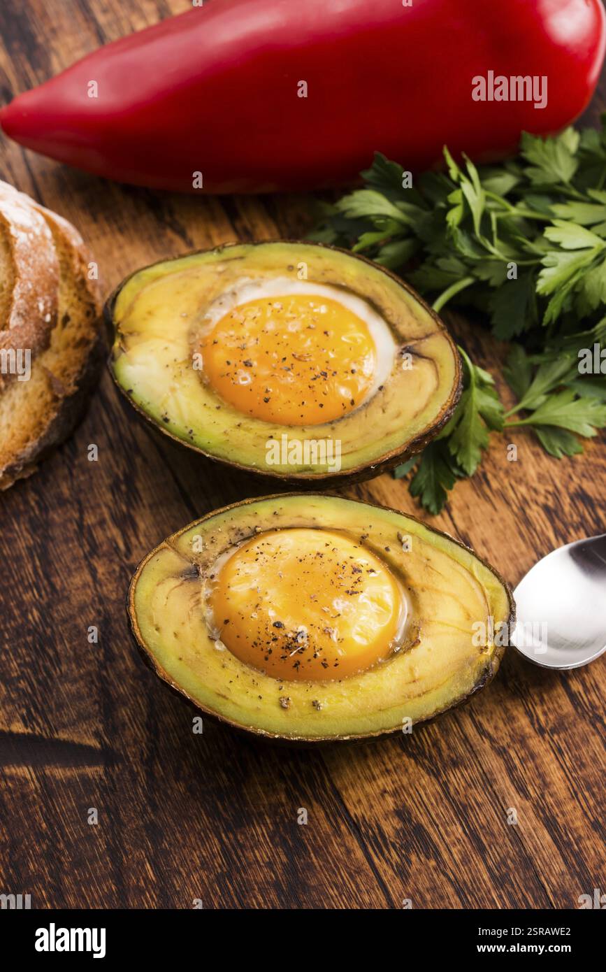 Oeufs bio faits maison cuit dans avocat avec sel et poivre Banque D'Images