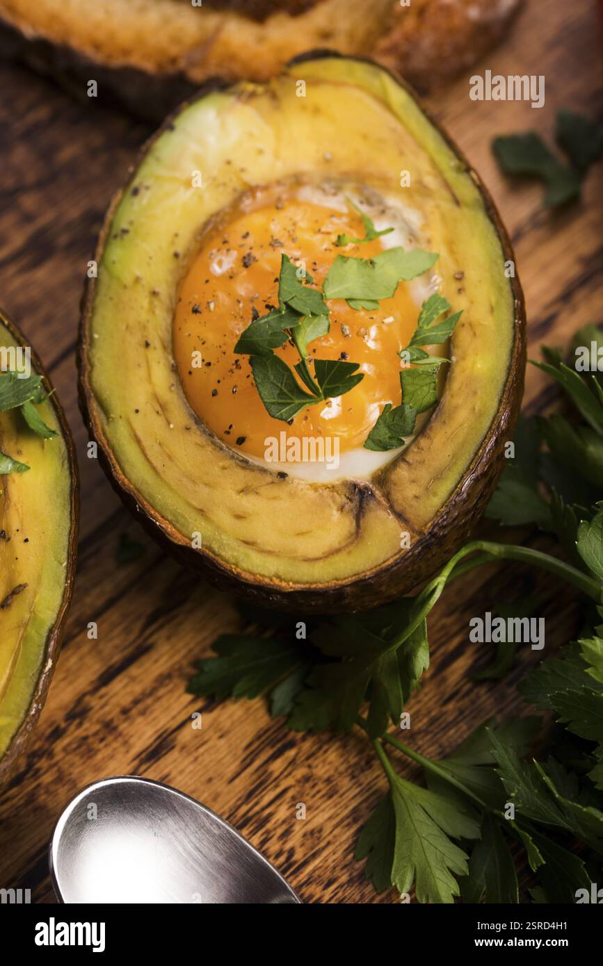 Oeufs bio faits maison cuit dans avocat avec sel et poivre Banque D'Images