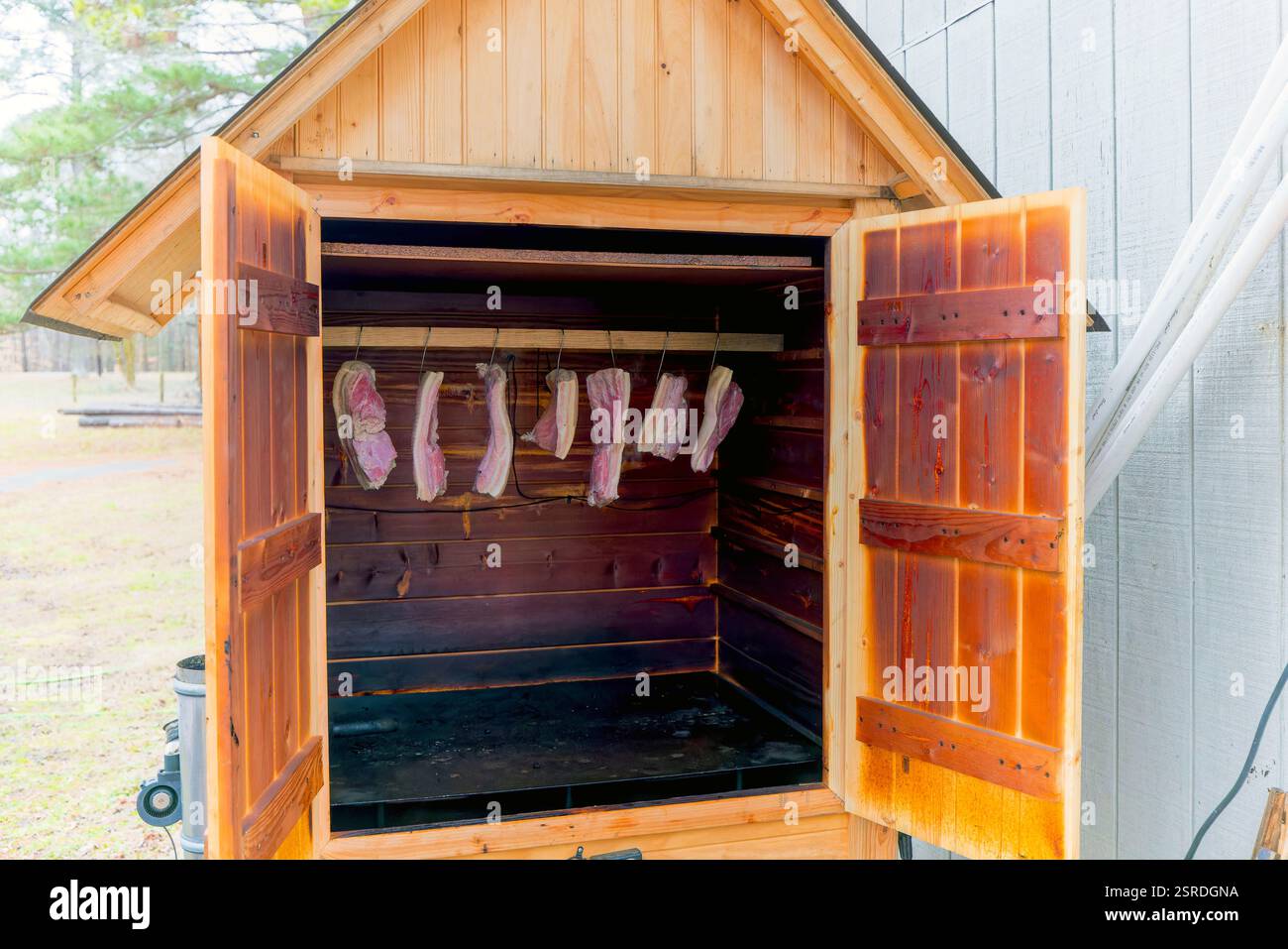 Smokehouse avec de la viande préparée et suspendue pour la fumée Banque D'Images