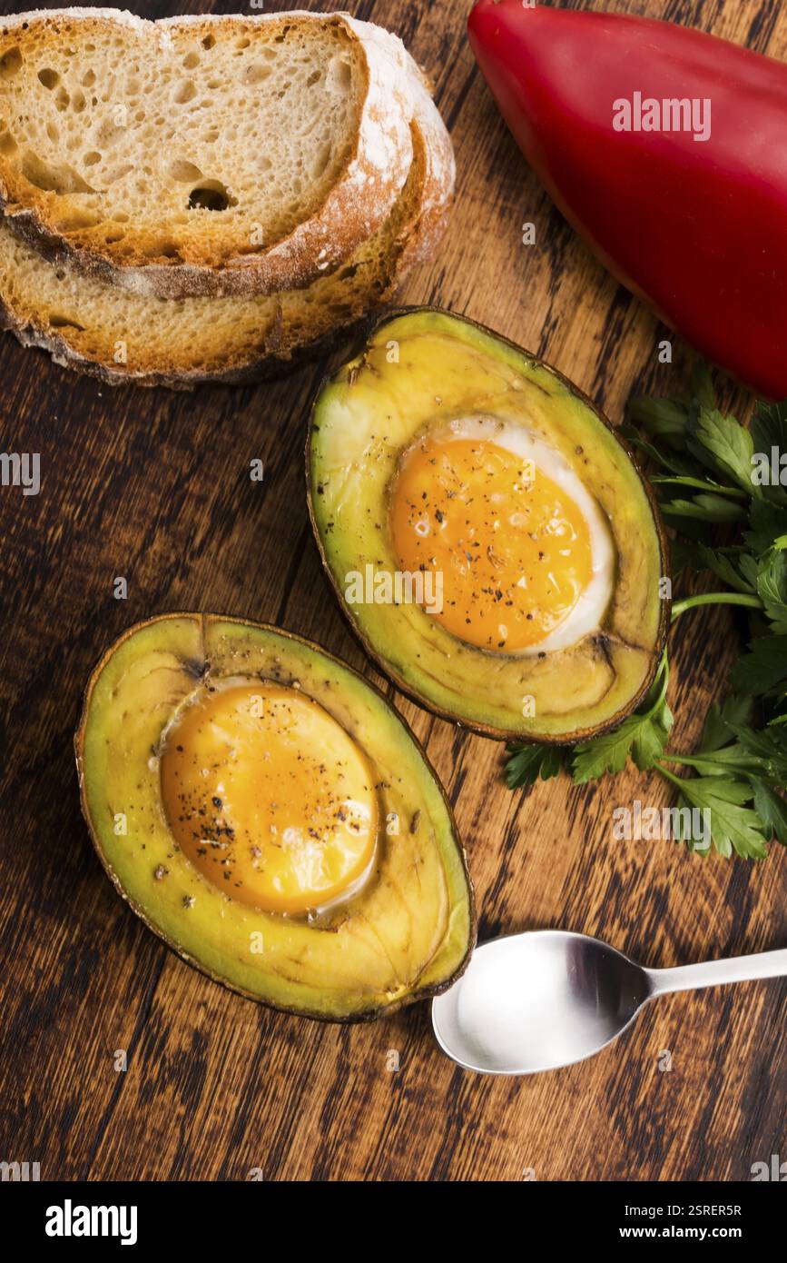 Oeufs bio faits maison cuit dans avocat avec sel et poivre Banque D'Images