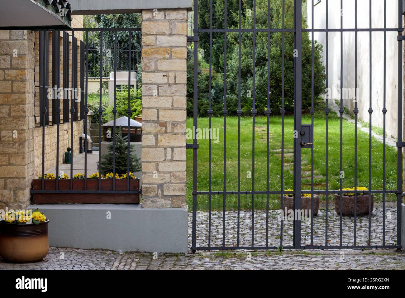 clôture en fer avec des pots de fleurs sur le trottoir. Banque D'Images
