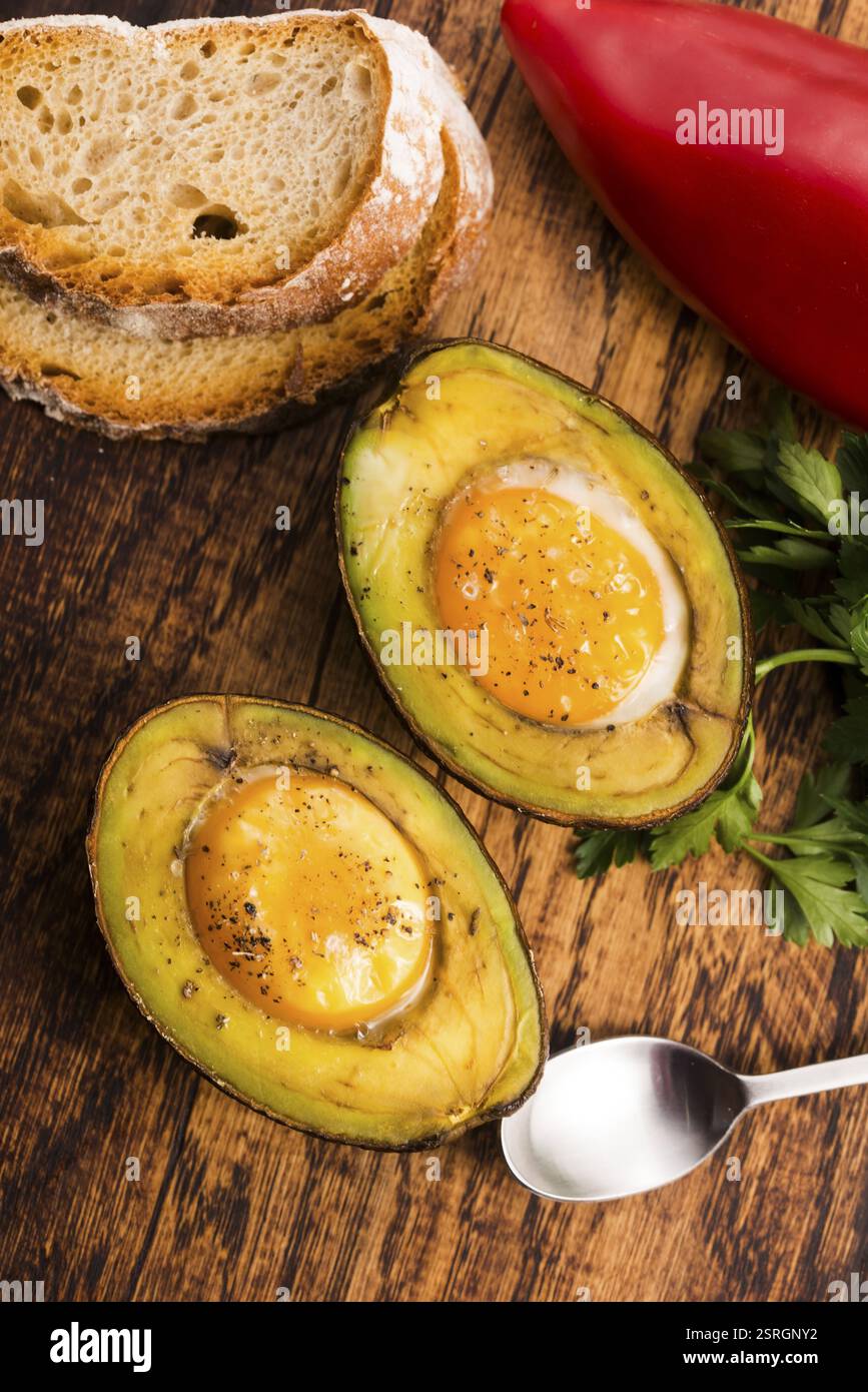 Oeufs bio faits maison cuit dans avocat avec sel et poivre Banque D'Images