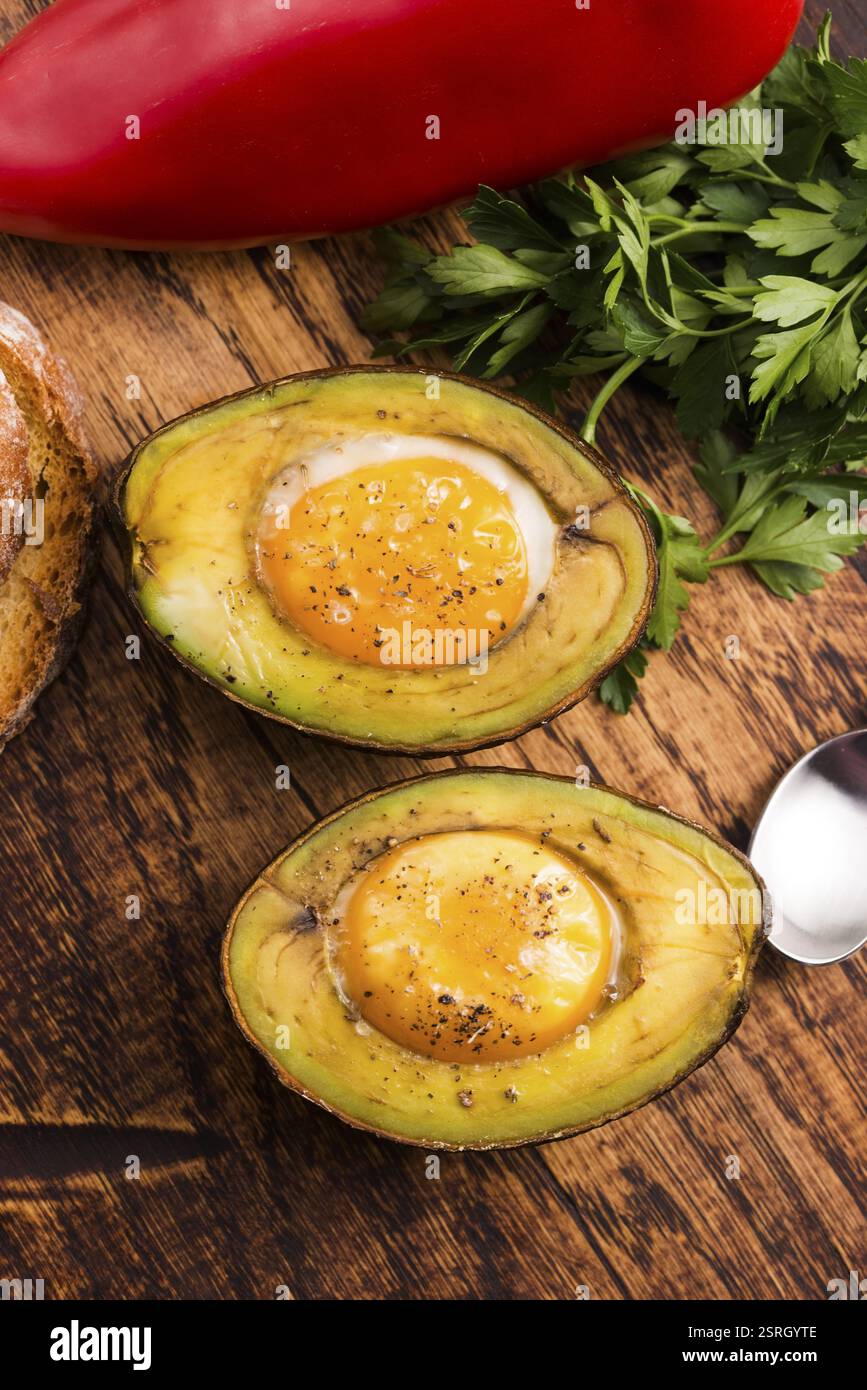 Oeufs bio faits maison cuit dans avocat avec sel et poivre Banque D'Images