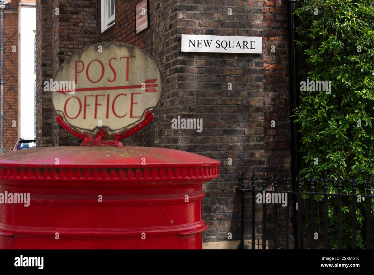Boîte aux lettres rouge au bureau de poste, New Square, Londres. Repère indiquant la direction vers le bureau. Banque D'Images