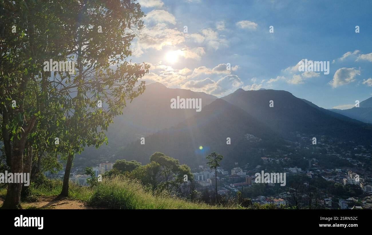 Ce paysage montagneux spectaculaire présente des sommets imposants et dentelés percant le ciel, enveloppés dans une forêt verdoyante. Banque D'Images