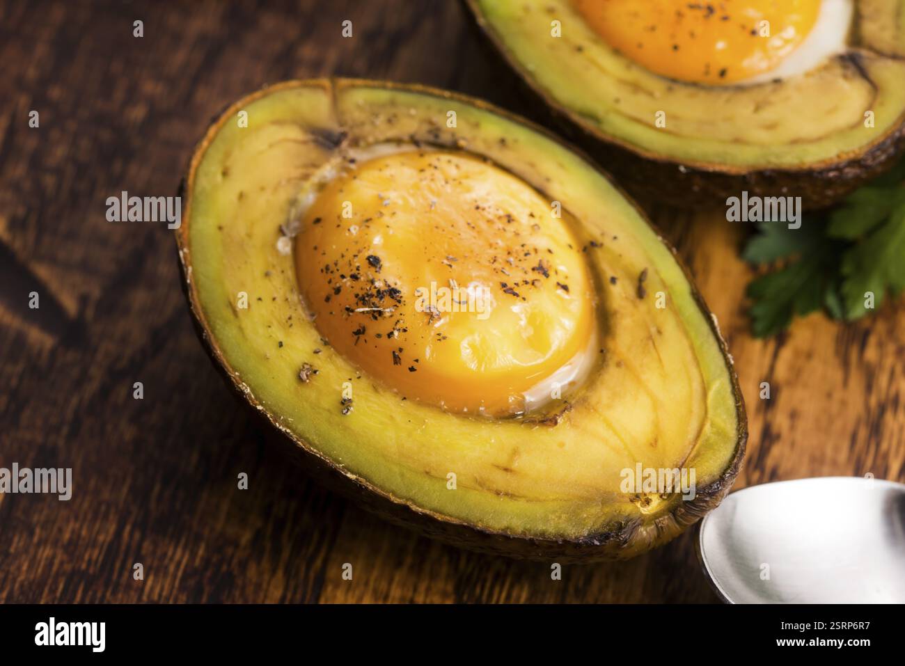 Oeufs bio faits maison cuit dans avocat avec sel et poivre Banque D'Images