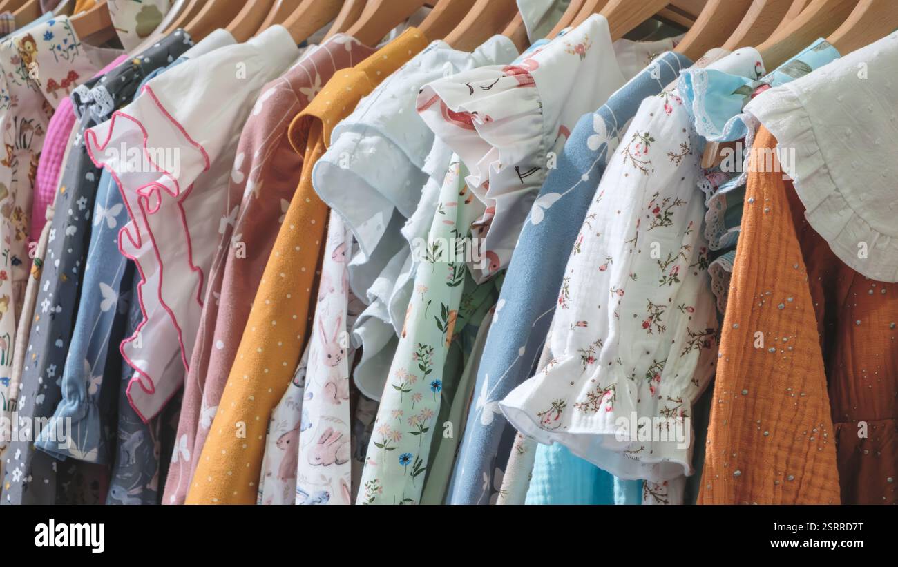 Un rack de vêtements avec une variété de couleurs et de motifs. Les vêtements sont suspendus sur un rack, et il existe de nombreux types de vêtements, y compris Banque D'Images