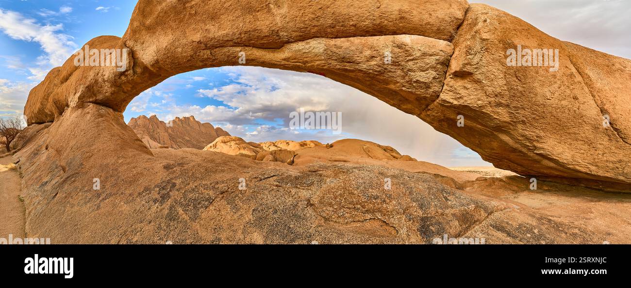 L'Arc de roche avec le petit Spitzkoppe en arrière-plan, des nuages, et une pluie avec un arc-en-ciel, Spitzkoppe, Namibie, Afrique Banque D'Images