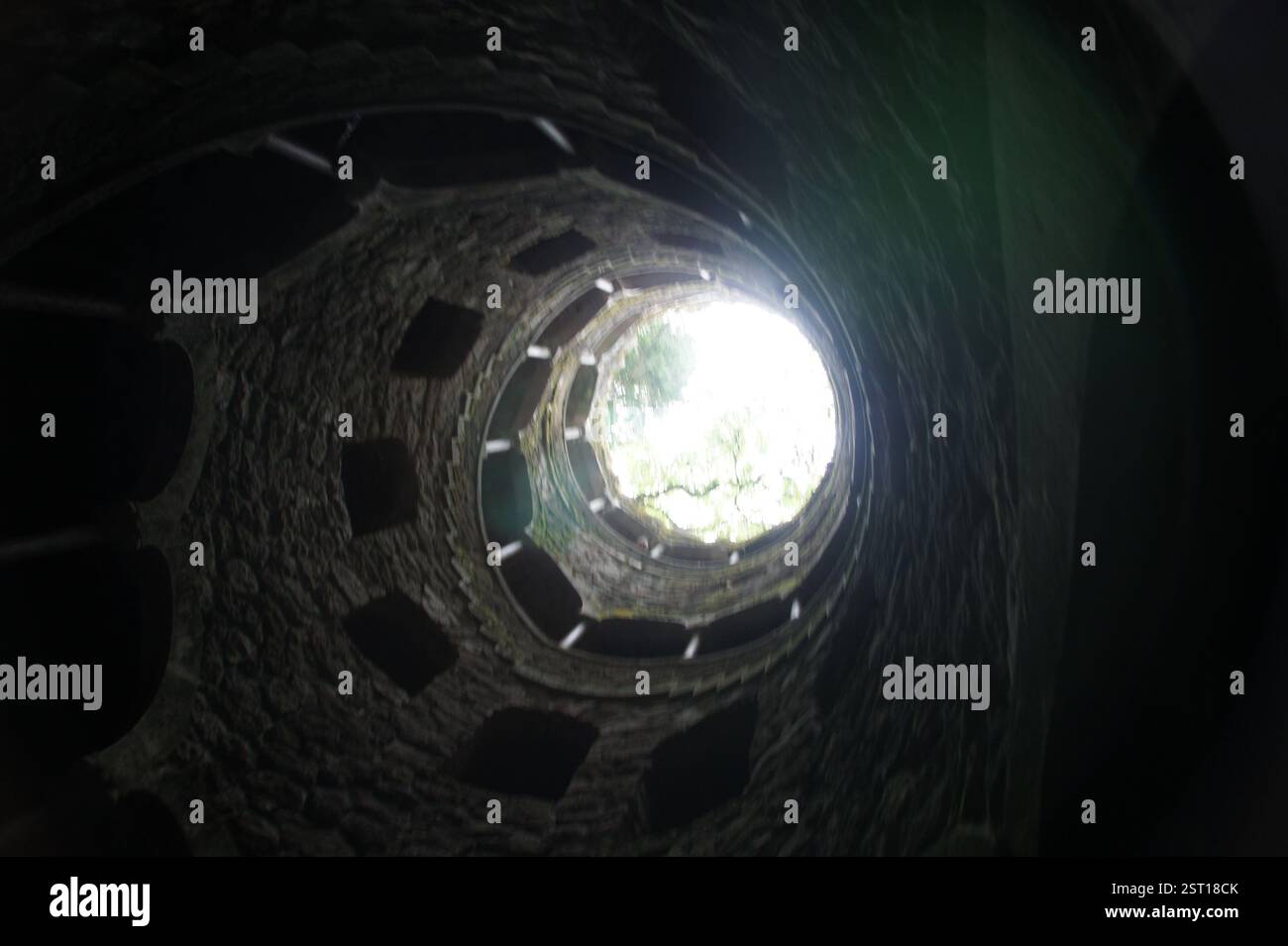 Sintra, Portugal : un fascinant escalier en colimaçon descend dans les profondeurs de la terre, évoquant le symbolisme puissant de la renaissance et de l'illumination spirituelle. Banque D'Images