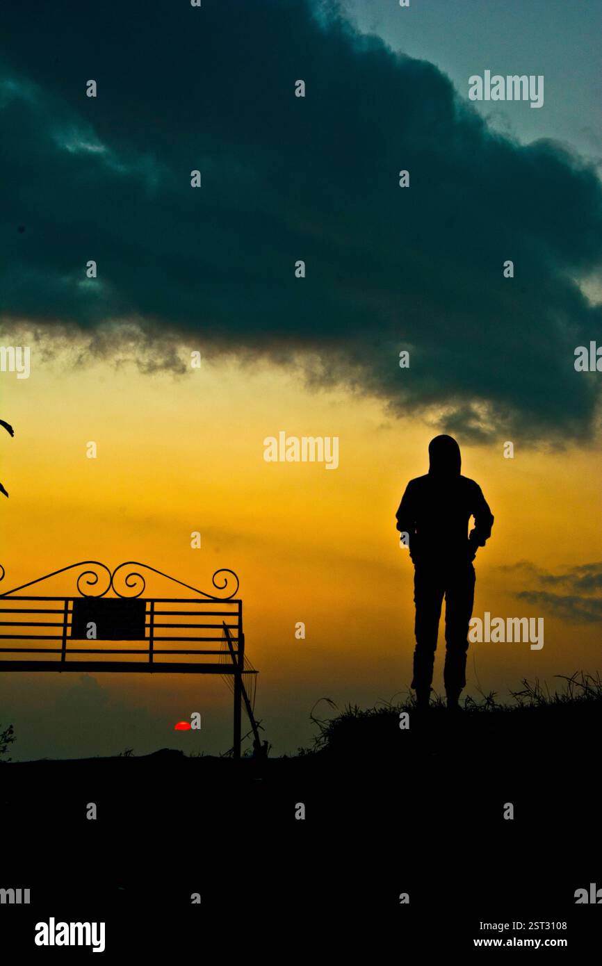 Un homme solitaire assis sur la verdure Banque D'Images