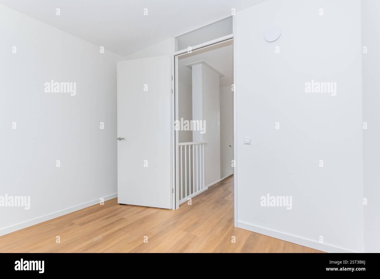 intérieur vide chambre de base non meublée dans la nouvelle construction moderne maison intelligente résidentielle. Les murs blancs Unis et les sols en vinyle effet bois font de la toile vierge Banque D'Images