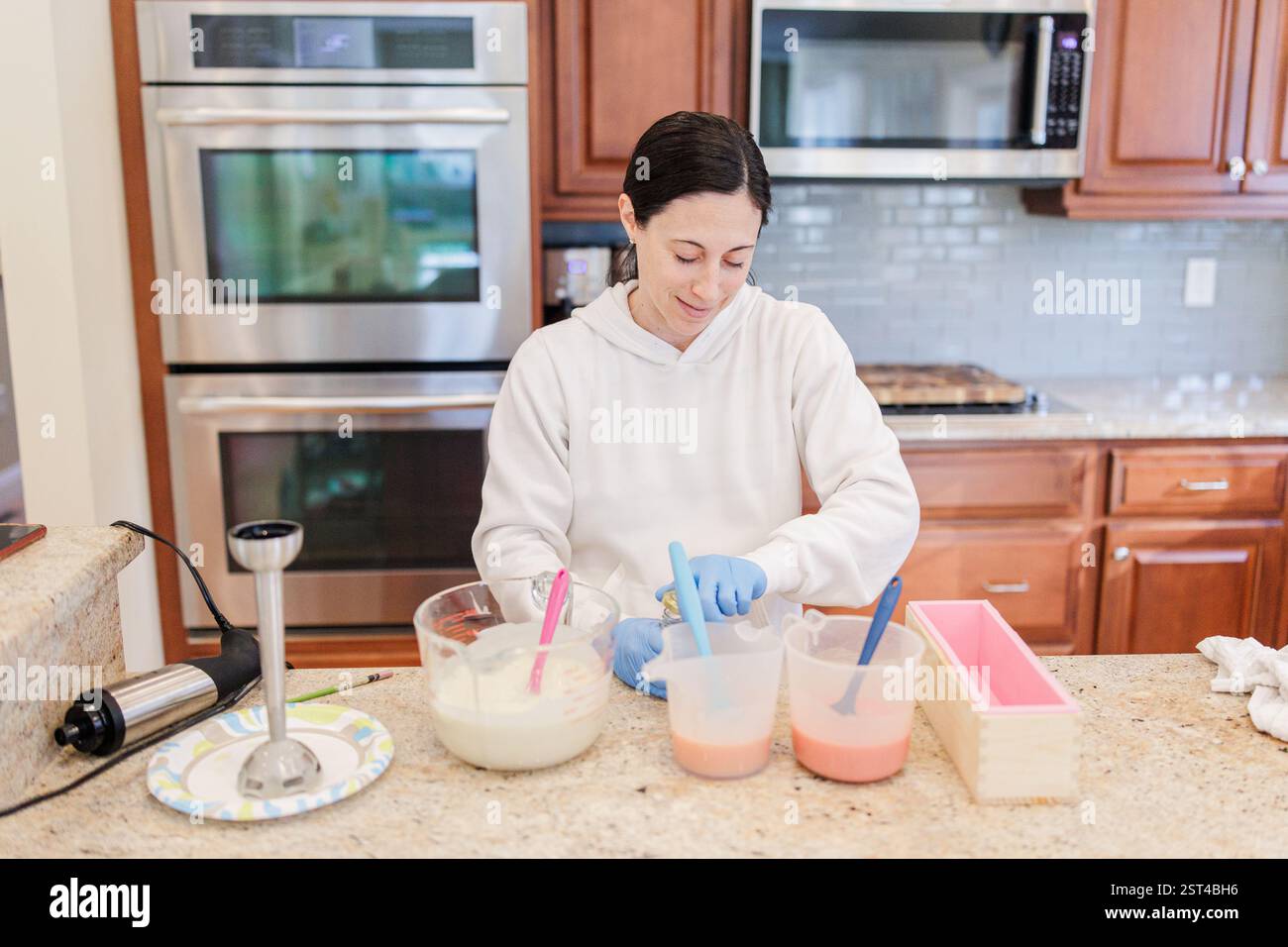 Femme se préparant à ajouter du mica doré aux mélanges de savon faits à la main dans Stow. Banque D'Images