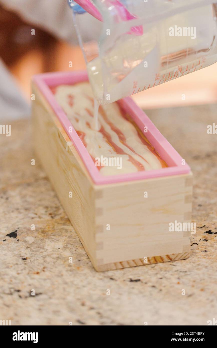 Gros plan de la couche de savon versée sur un tourbillon de mica doré dans le moule Banque D'Images