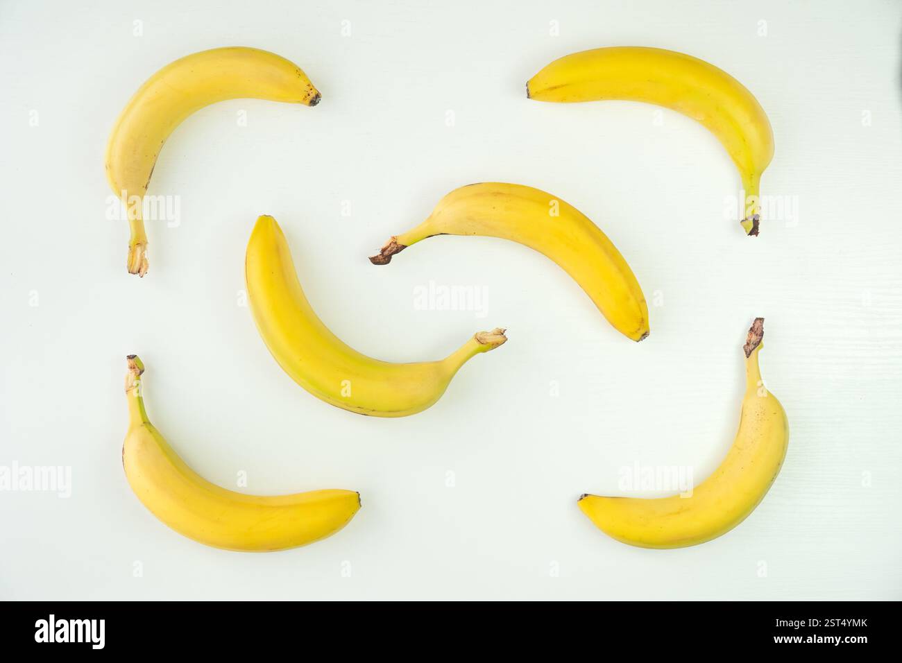 Photo vue de dessus de bananes jaunes non pelées sur fond blanc Banque D'Images