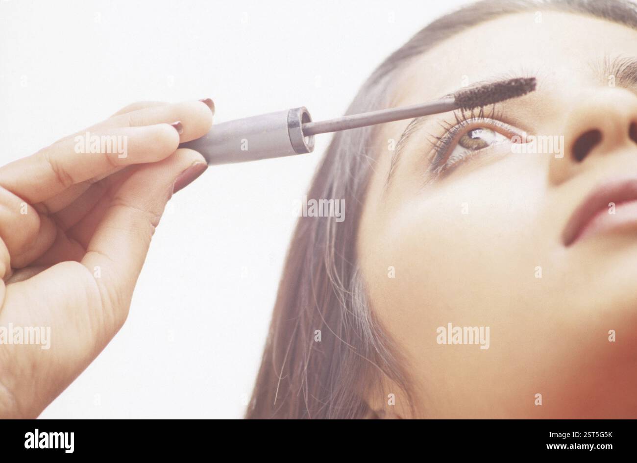 Woman applying Make-up Banque D'Images