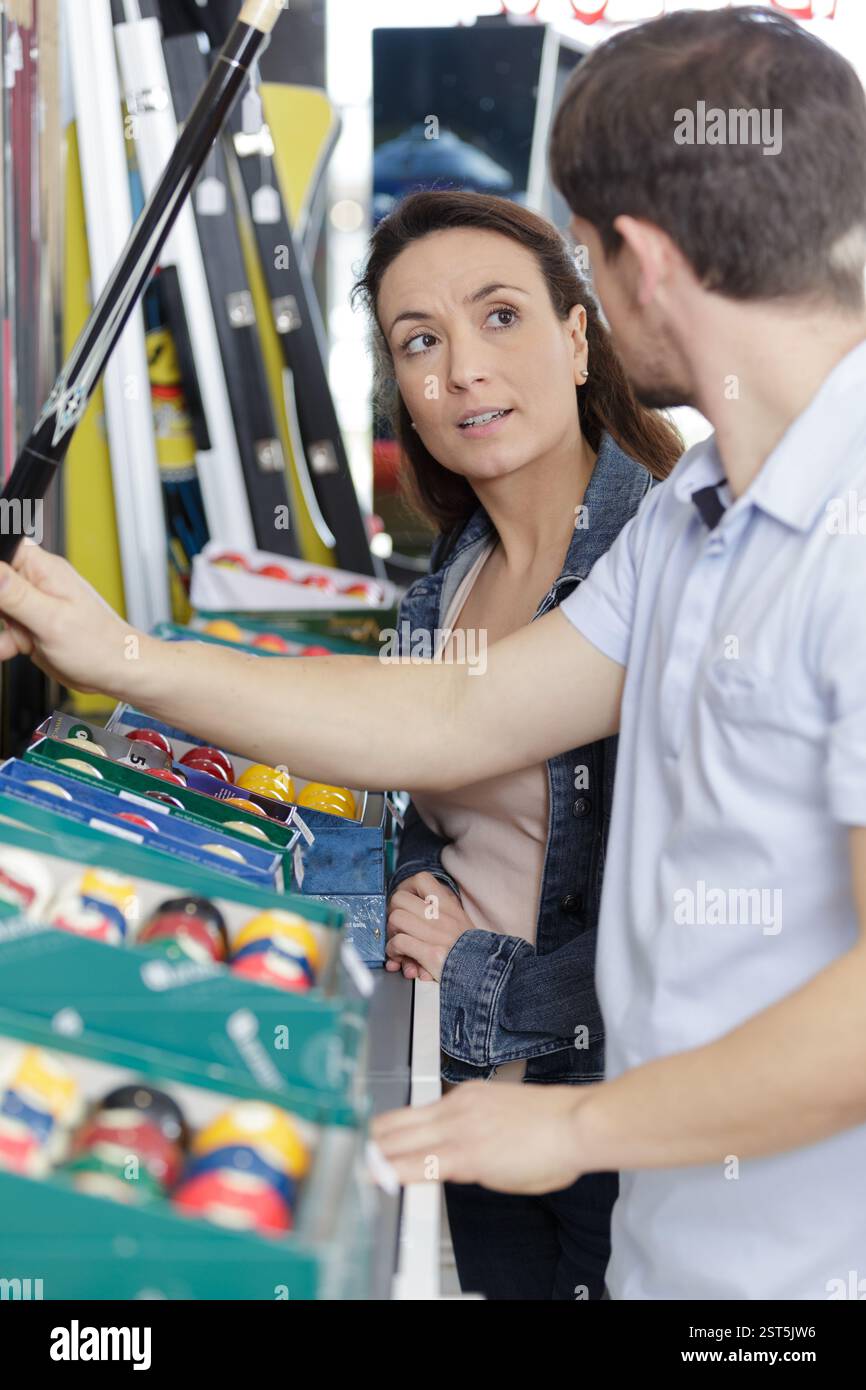 un couple achetant des accessoires de billard Banque D'Images