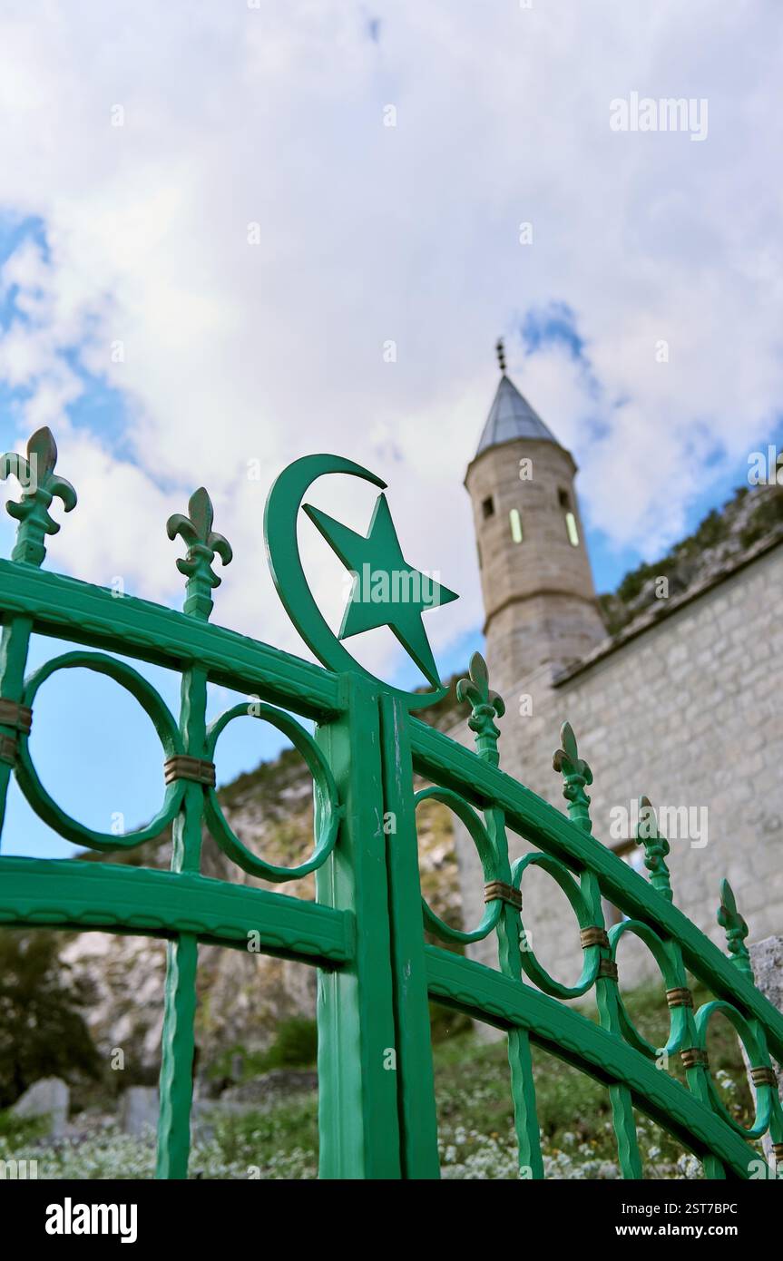 Symboles étoile et croissant de l'Islam et symbole Fleur de lis du Royaume de Bosnie, sur fond minaret flou de la mosquée Kljuc, Gacko, Bosnie et Herz Banque D'Images