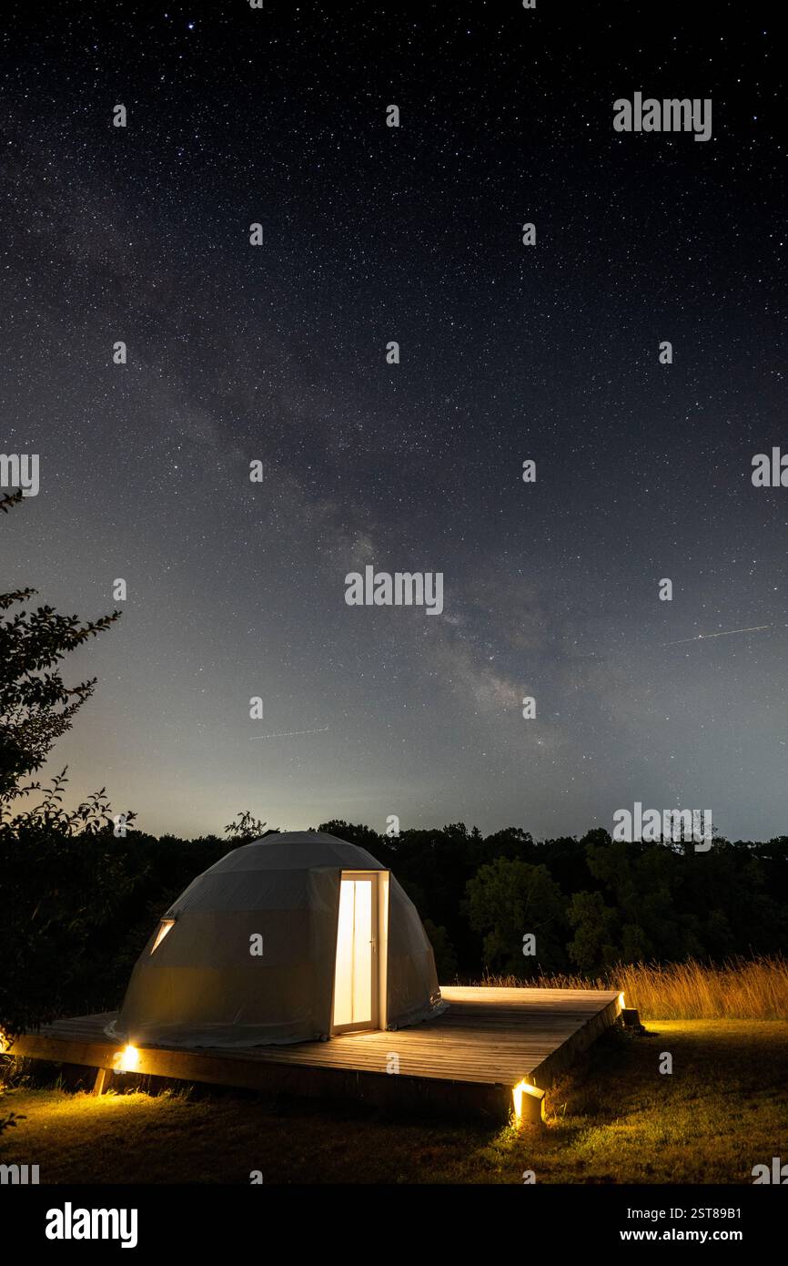 La voie Lactée s'élève au-dessus d'un dôme de glamping Banque D'Images