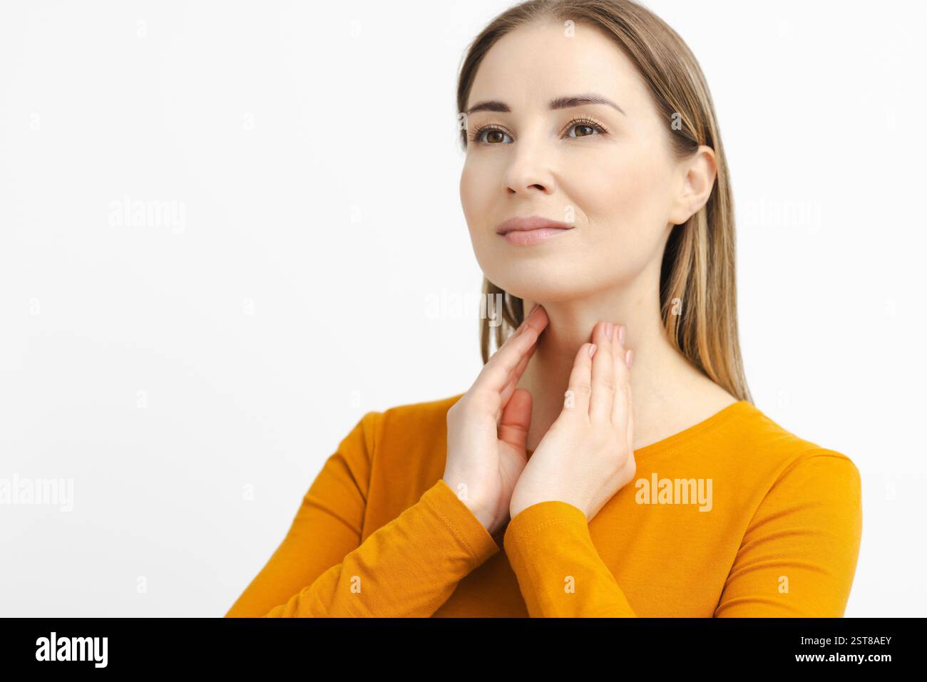 Femme touchant elle-même son cou pour vérifier la glande thyroïde. Prévention et maladie du système endocrinien Banque D'Images