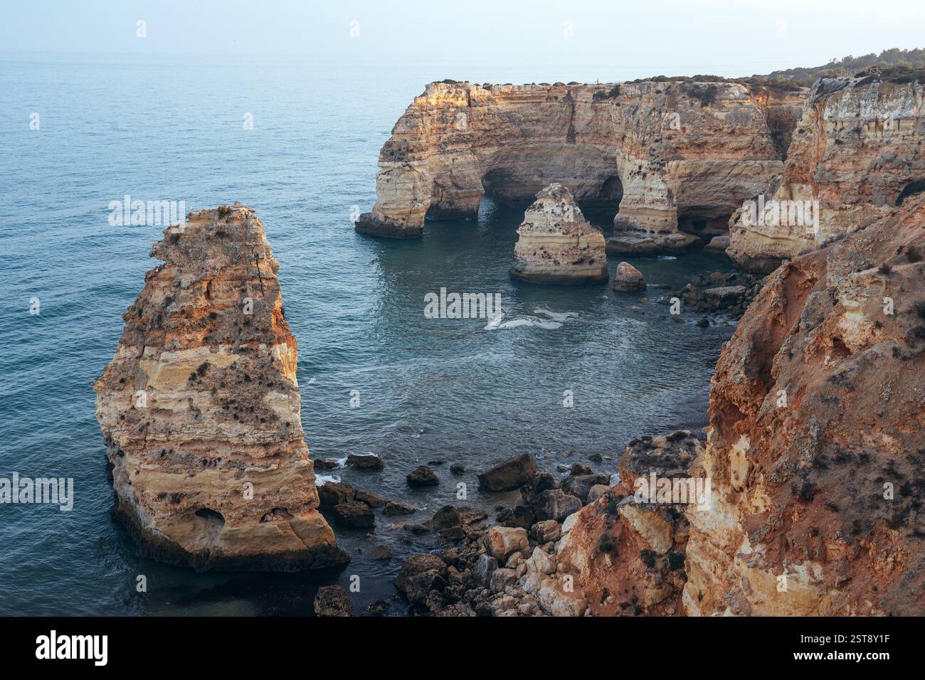 Falaises, formations rocheuses et arches naturelles sur la plage de la Marina au coucher du soleil dans la région de l'Algarve près des villes d'Albufeira et Portimao. Portugal. Banque D'Images