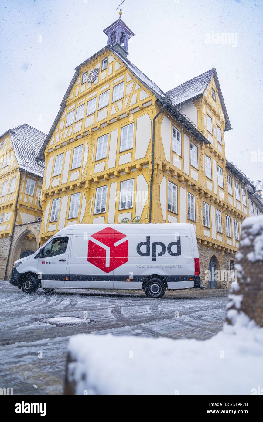 Une camionnette de livraison DPD se trouve devant un bâtiment à colombages peint en jaune recouvert de neige, Sindelfingen, Allemagne, Europe Banque D'Images